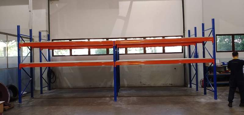 Two empty bays of V3000 racking with blue uprights and orange beams in a workshop, windows behind - V3000 Racking - V3-1 | Wong Lye Racking, Singapore Racking Manufacturer