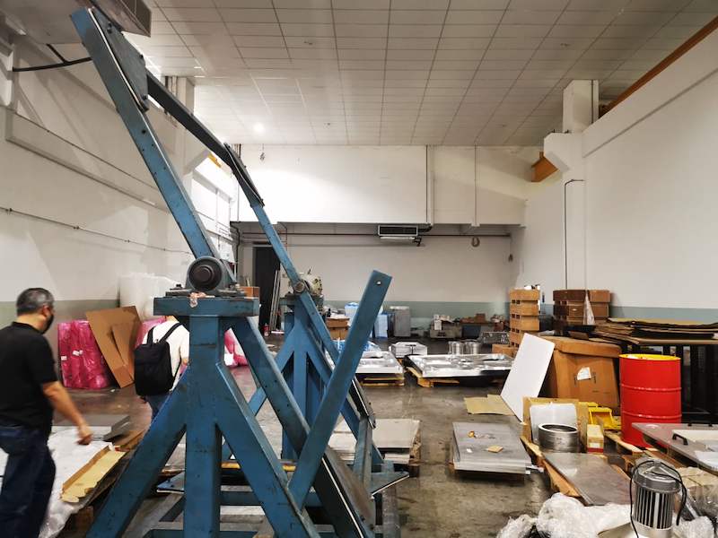 Workshop floor with machinery and steel plates on pallets beside the racking installation - V3000 Racking - V3-1 | Wong Lye Racking, Singapore Racking Manufacturer