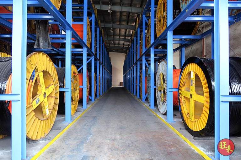 After: aisle between two runs of blue steel V10000 racking fully loaded with cable drums, yellow aisle lines on the floor - V10000 Racking - V10-1 | Wong Lye Racking, Singapore Racking Manufacturer