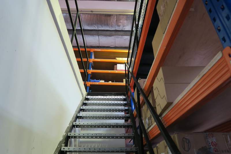 Foot of the perforated-tread staircase between blue uprights and orange beams - V5000 Racking - V5-8 | Wong Lye Racking, Singapore Racking Manufacturer