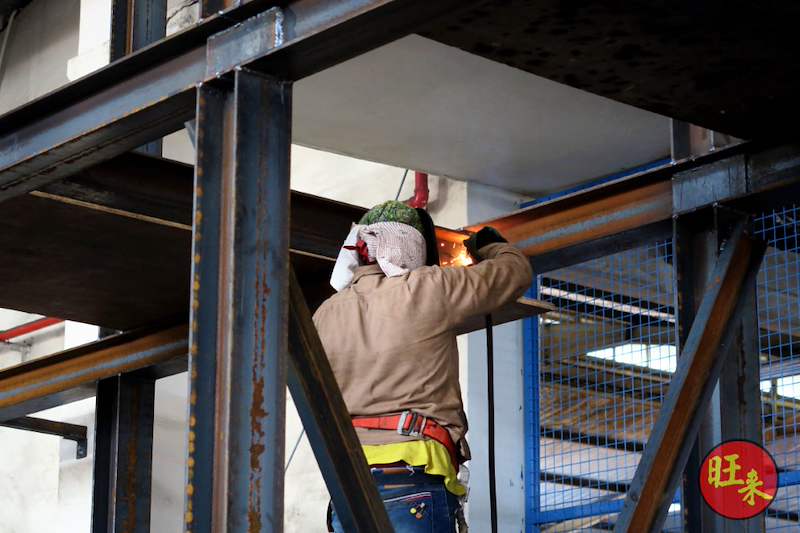 Welder joining a steel beam to a column of the racking structure - V10000 Racking - V10-1 | Wong Lye Racking, Singapore Racking Manufacturer
