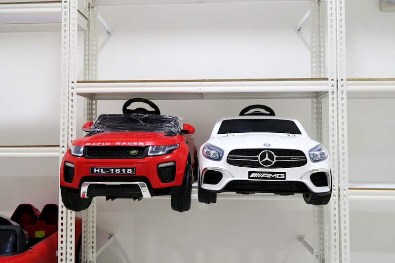 Red and white ride-on toy cars on a white boltless shelf between slotted uprights - Boltless Racking - B3 | Wong Lye Racking, Singapore Racking Manufacturer