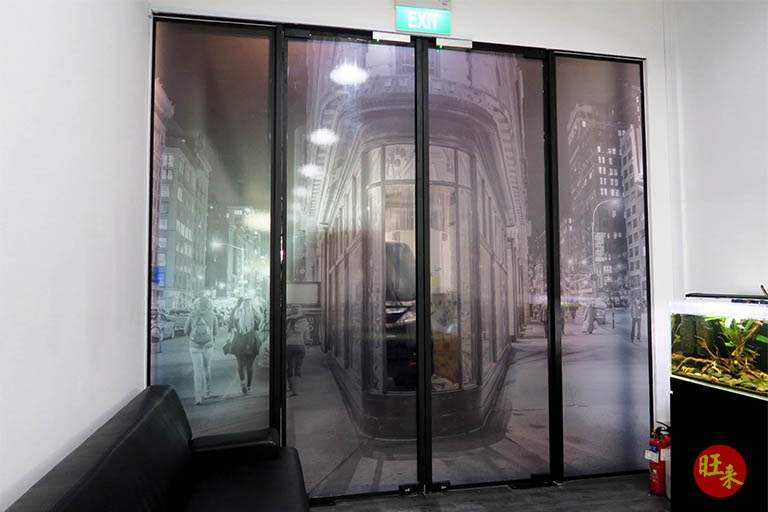 Entrance area with a printed glass sliding door and exit sign below the mezzanine - V5000 Racking - V5-13 | Wong Lye Racking, Singapore Racking Manufacturer