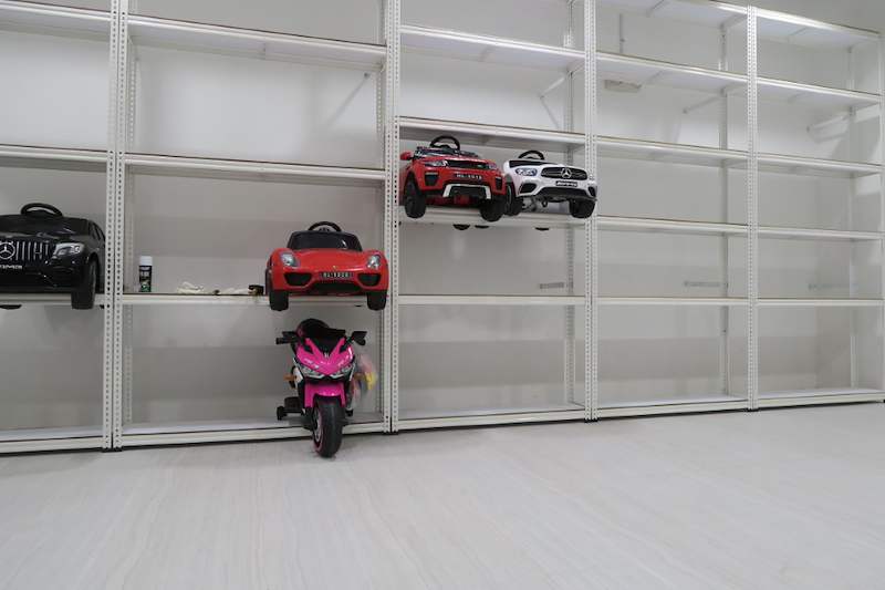 White boltless shelving along the wall with ride-on toy cars and a toy motorcycle on the floor level - Boltless Racking - B3 | Wong Lye Racking, Singapore Racking Manufacturer