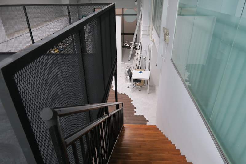 Looking down the timber staircase from the mezzanine deck, mesh railing beside it - V5000 Racking - V5-16 | Wong Lye Racking, Singapore Racking Manufacturer
