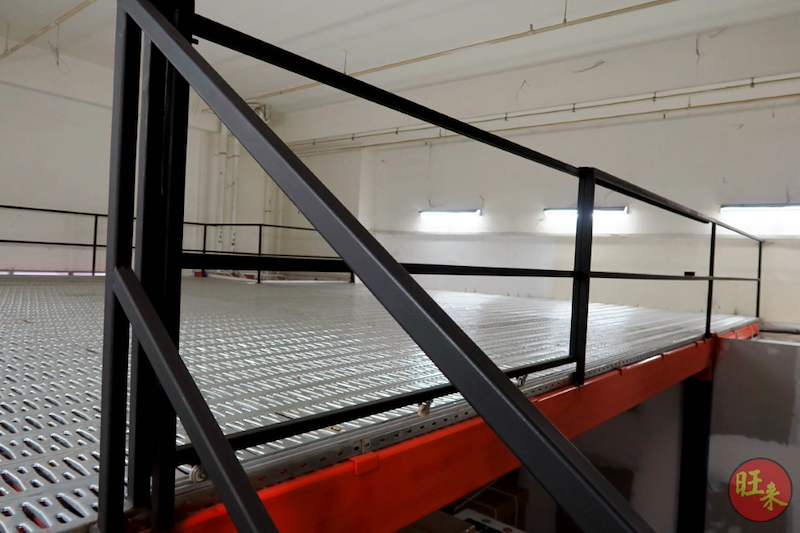 Mezzanine deck with black railing and staircase handrail, perforated steel decking and red edge beam - V6000 Racking - V6-7 | Wong Lye Racking, Singapore Racking Manufacturer