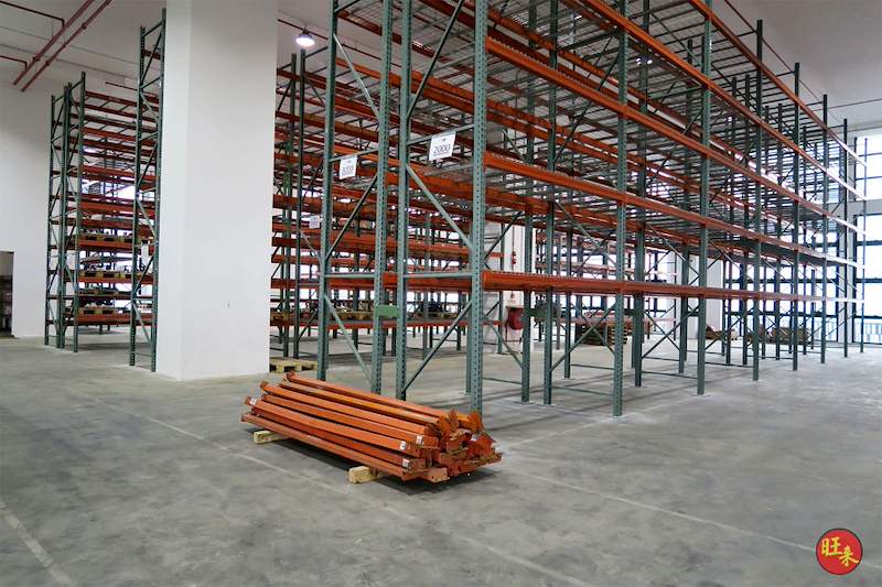 Pallet racking beside a column with a bundle of orange beams on a pallet, install in progress - V3000 Racking - V3-3 | Wong Lye Racking, Singapore Racking Manufacturer