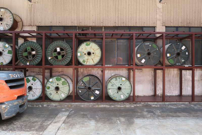 Front view of the two-tier steel rack with cable drums in each bay and a forklift alongside - V5000 Racking - V5-1 | Wong Lye Racking, Singapore Racking Manufacturer