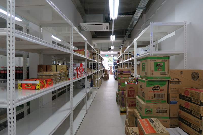 Long aisle of white boltless shelving with packaged goods and cartons of stock - Boltless Racking - B6 | Wong Lye Racking, Singapore Racking Manufacturer