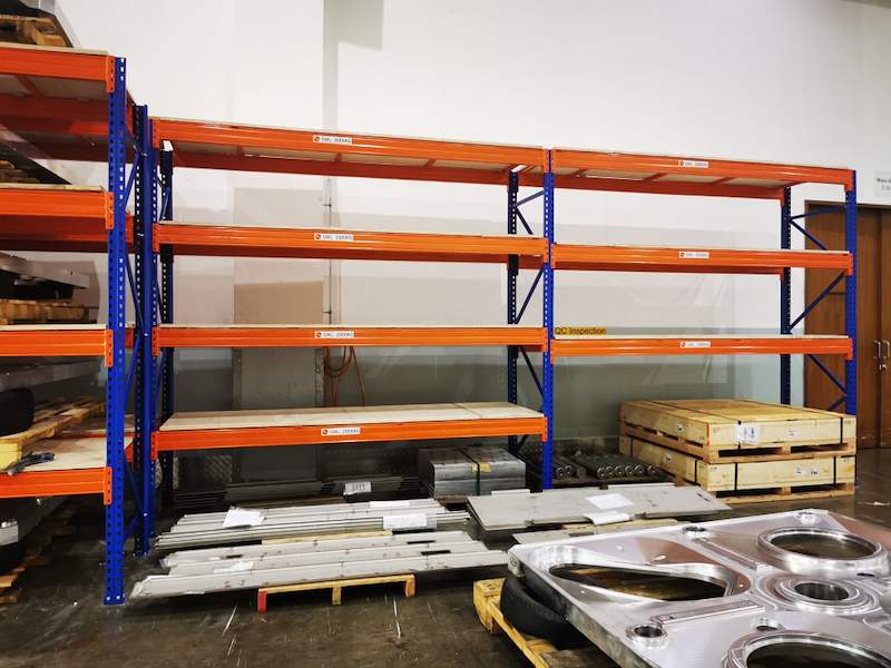 Three bays of V3000 racking loaded with steel parts on pallets, machined plates stacked on the floor - V3000 Racking - V3-1 | Wong Lye Racking, Singapore Racking Manufacturer