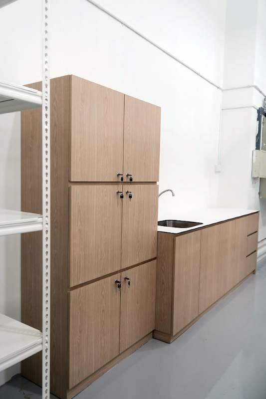 Timber-laminate pantry cabinets and sink counter beside a white boltless shelving unit - Boltless Racking - B8 | Wong Lye Racking, Singapore Racking Manufacturer