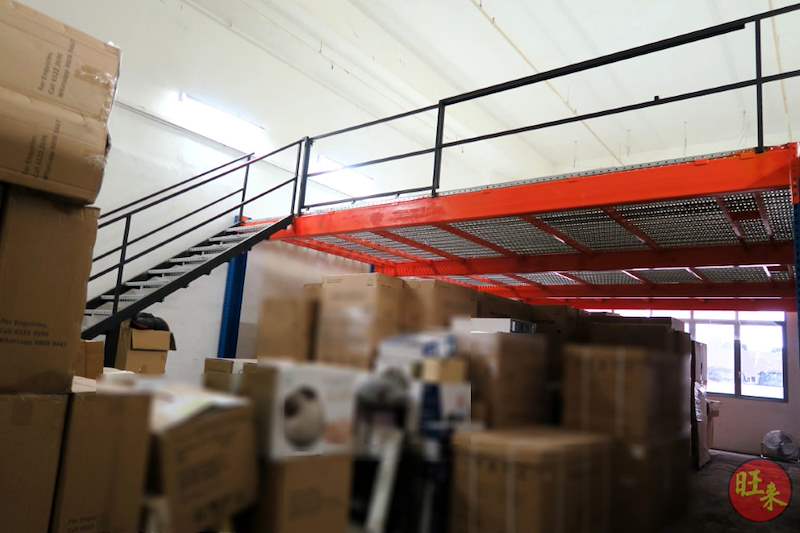 Mezzanine deck with red beams and black railing over stacked cartons, seen from the stock area below - V6000 Racking - V6-7 | Wong Lye Racking, Singapore Racking Manufacturer