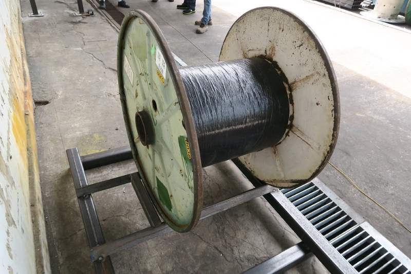 Cable drum resting in the steel base frame close up, drain grating behind - V5000 Racking - V5-1 | Wong Lye Racking, Singapore Racking Manufacturer