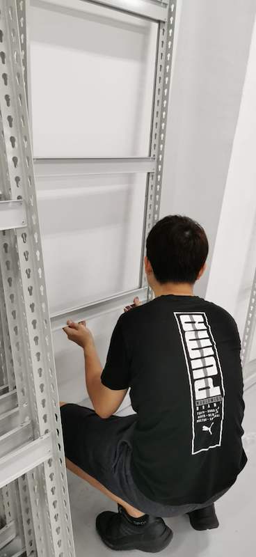 Installer fitting a shelf panel to a boltless shelving upright during assembly - Boltless Racking - B1 | Wong Lye Racking, Singapore Racking Manufacturer