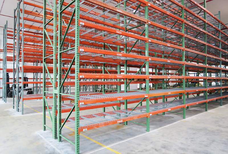 Rows of pallet racking with orange beams and wire mesh decking in the warehouse - V3000 Racking - V3-3 | Wong Lye Racking, Singapore Racking Manufacturer