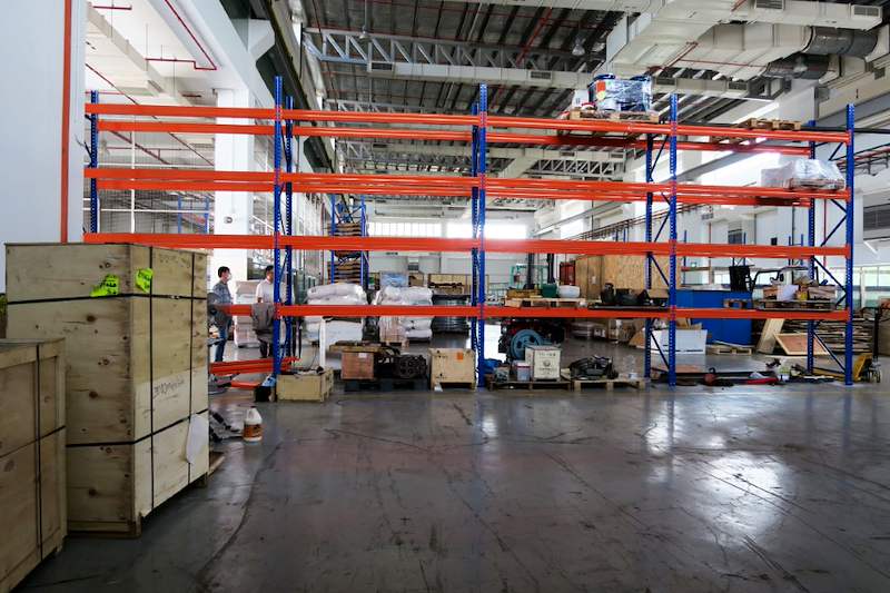 V3000 racking runs with timber crates and pallets on the floor between them - V3000 Racking - V3-5 | Wong Lye Racking, Singapore Racking Manufacturer
