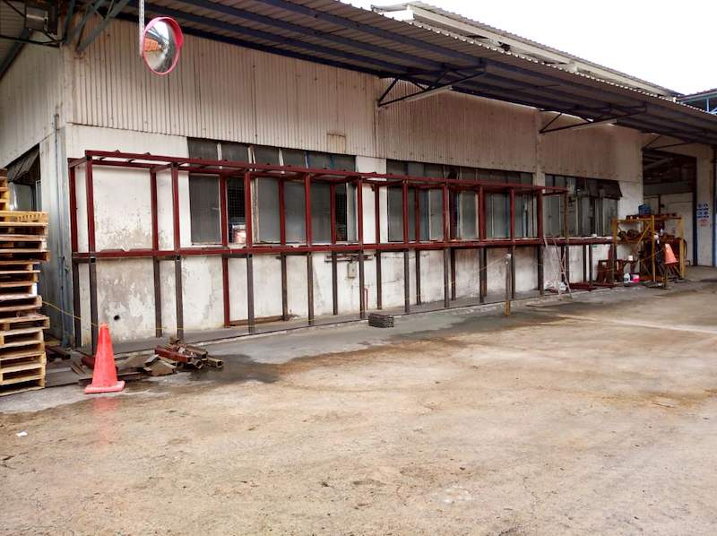 Two-tier steel rack frame with red-oxide finish along an outdoor wall, bays empty - V5000 Racking - V5-1 | Wong Lye Racking, Singapore Racking Manufacturer