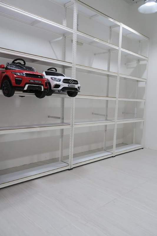 Long run of white boltless shelving along the wall with toy cars on one bay, rest of the shelves empty - Boltless Racking - B3 | Wong Lye Racking, Singapore Racking Manufacturer