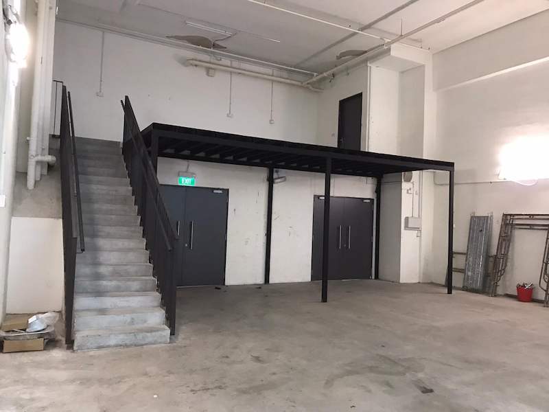 Mezzanine platform and staircase with black balustrade above double doors in an empty unit - V5000 Racking - V5-9 | Wong Lye Racking, Singapore Racking Manufacturer