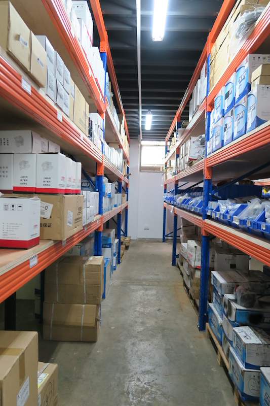 Aisle between two runs of blue-and-orange racking with cartons on every level - V5000 Racking - V5-8 | Wong Lye Racking, Singapore Racking Manufacturer