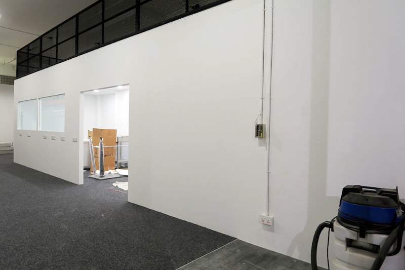 White partition wall with glass windows under the mezzanine floor, carpeted office floor - V5000 Racking - V5-13 | Wong Lye Racking, Singapore Racking Manufacturer