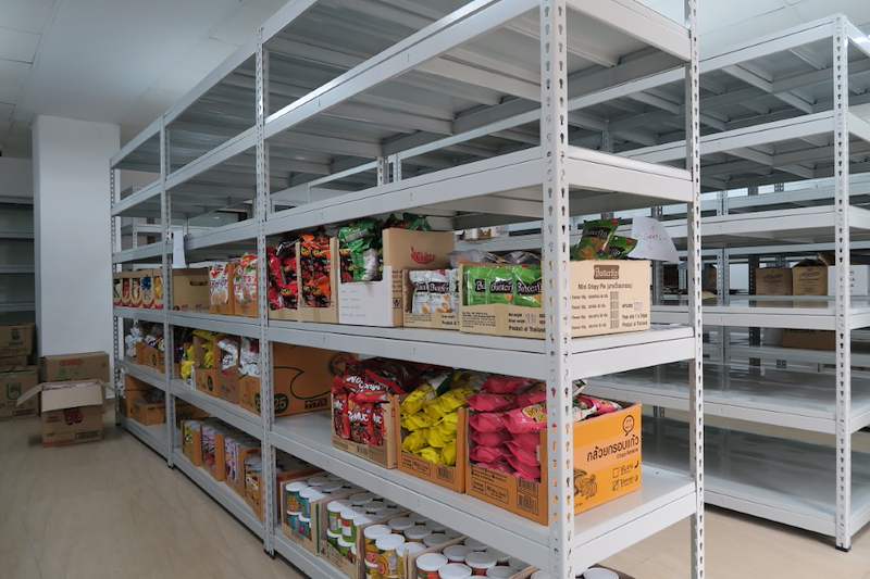 Boltless shelving bays stocked with bagged snacks and cans, more empty bays beyond - Boltless Racking - B2 | Wong Lye Racking, Singapore Racking Manufacturer