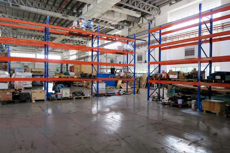 Two V3000 racking runs in the workshop, crates and parts on the floor and lower levels - V3000 Racking - V3-5 | Wong Lye Racking, Singapore Racking Manufacturer